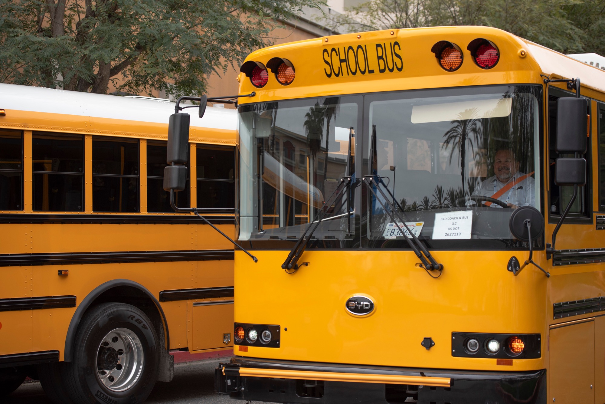 Photograph of a young student next to a school bus