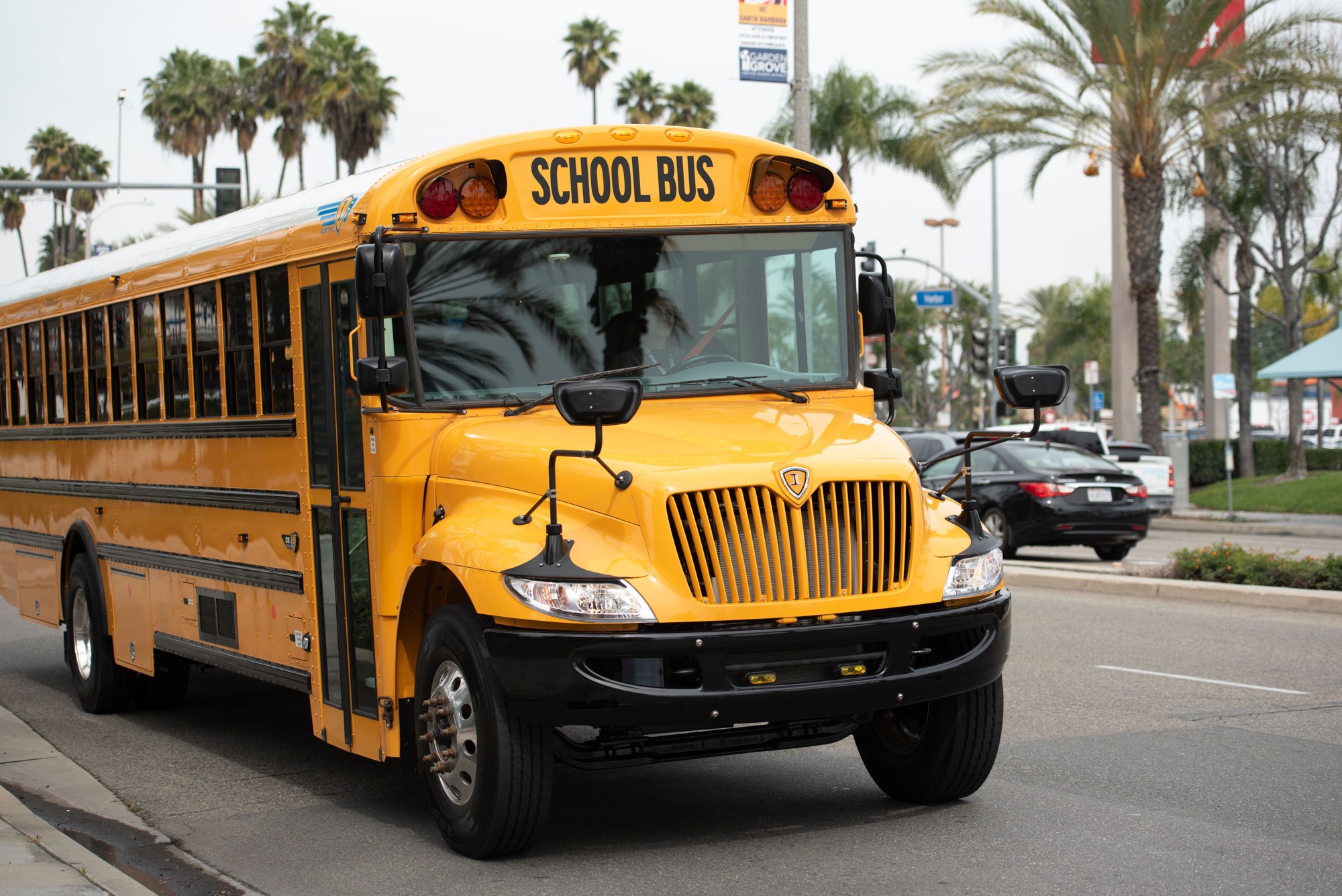 Photograph of an electric school bus connected to a charger